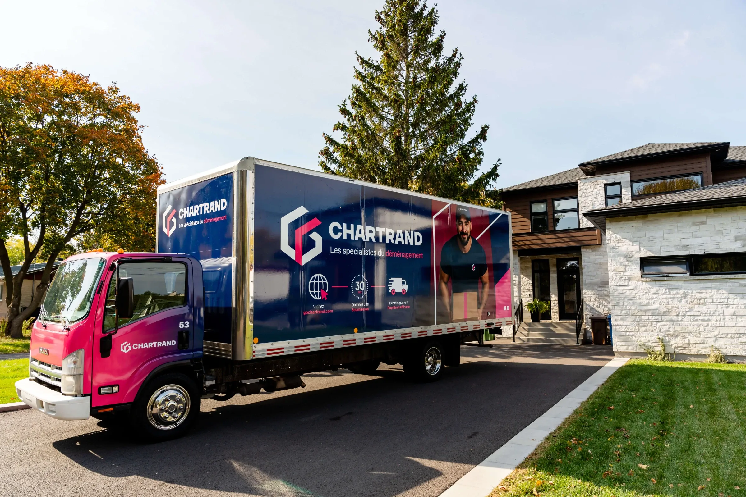 Camion Chartrand garé dans l’allée d’une maison moderne en pierre