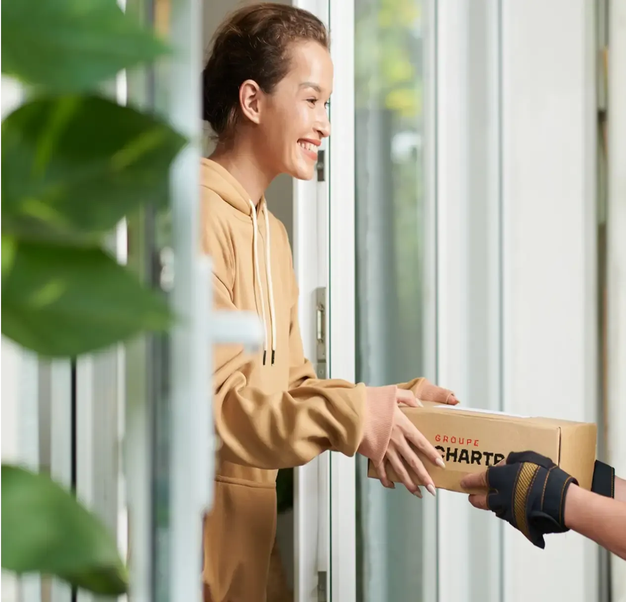 Une cliente souriante reçoit une boîte Chartrand à sa porte