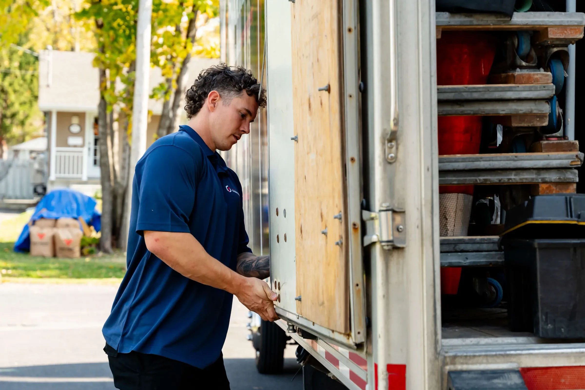Déménageur Chartrand ouvrant la porte latérale d’un camion rempli d’équipement