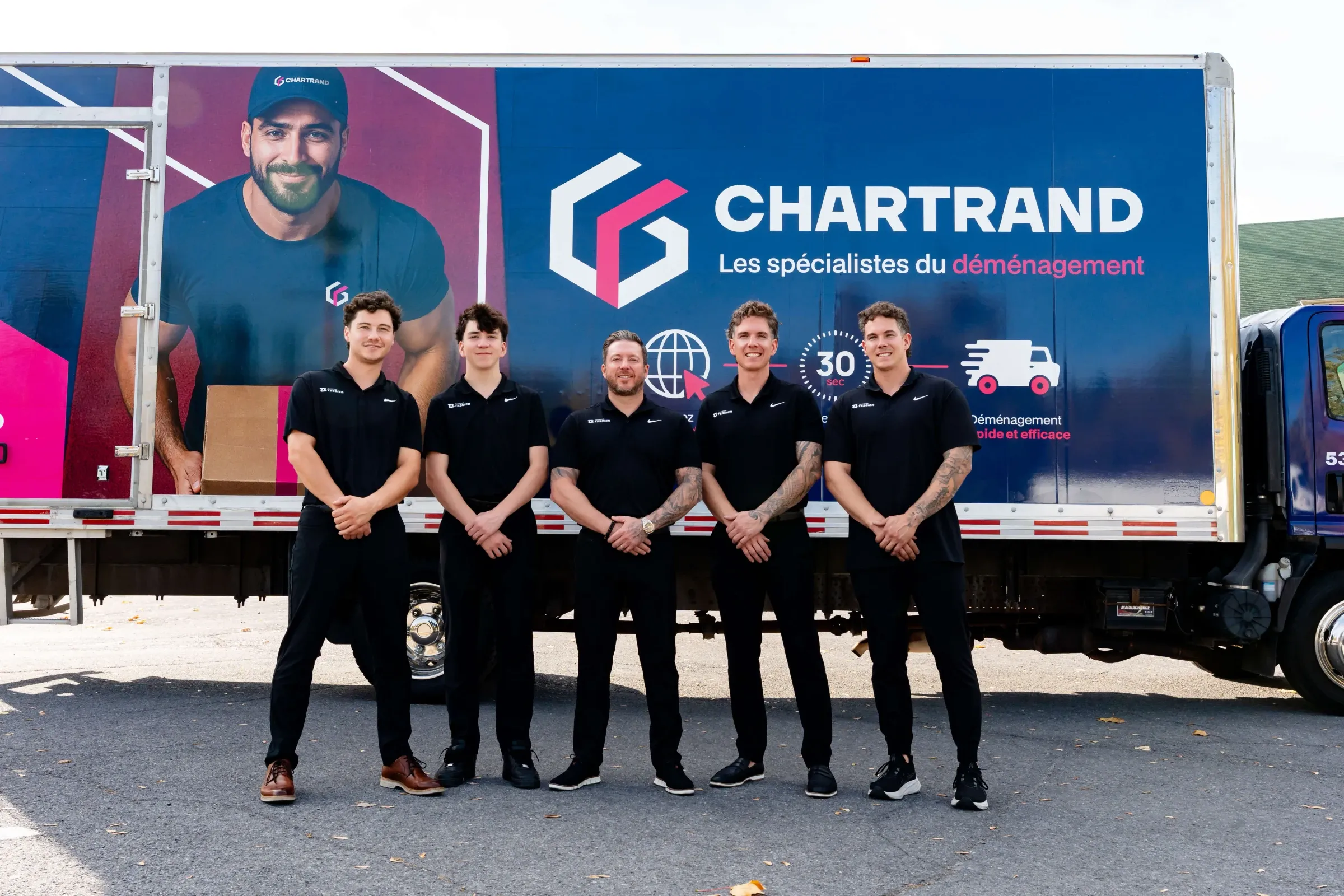 Équipe de cinq déménageurs Chartrand devant un camion de la flotte